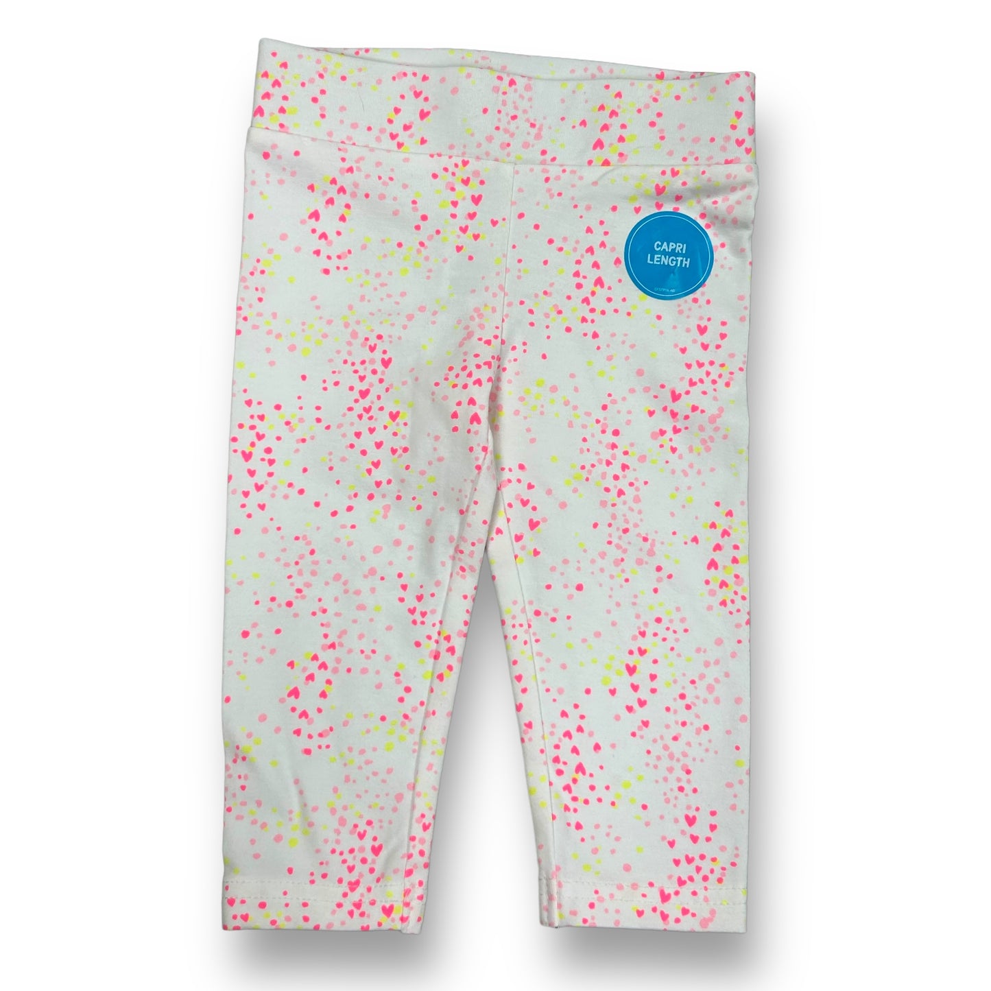 A pair of white capris with a heart print, featuring pink and green hearts and dots pattern.