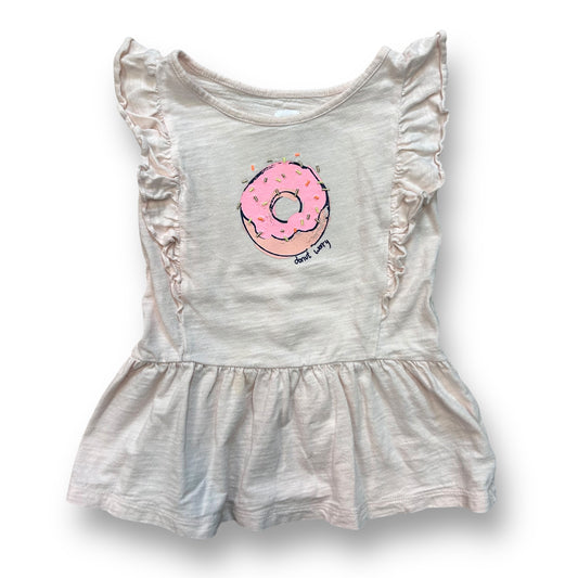 A pale pink girls' dress with a donut design on the front and ruffled sleeves and skirt.