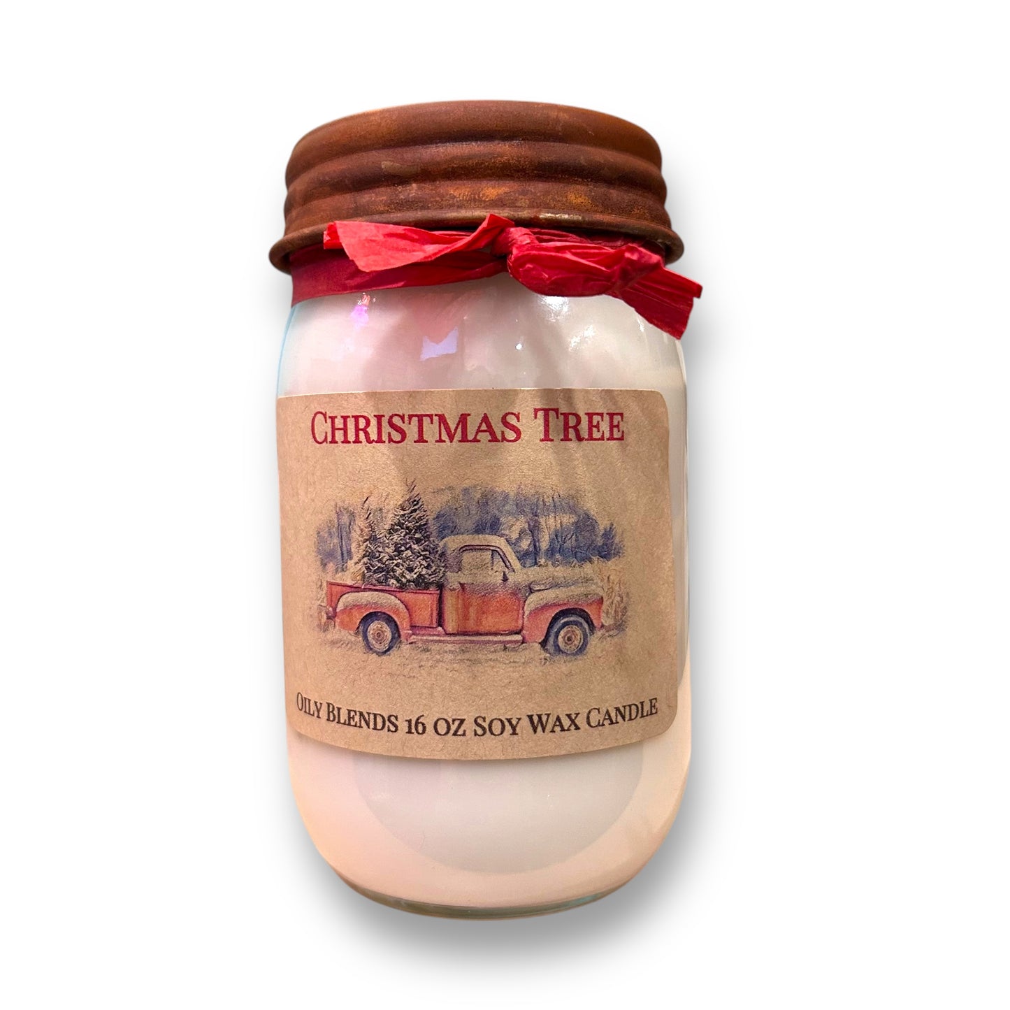 A soy wax candle with a Christmas tree scent, packaged in a glass jar with a brown lid and a red ribbon, featuring a label with 'Christmas Tree' and a graphic of a Christmas tree and sleigh.