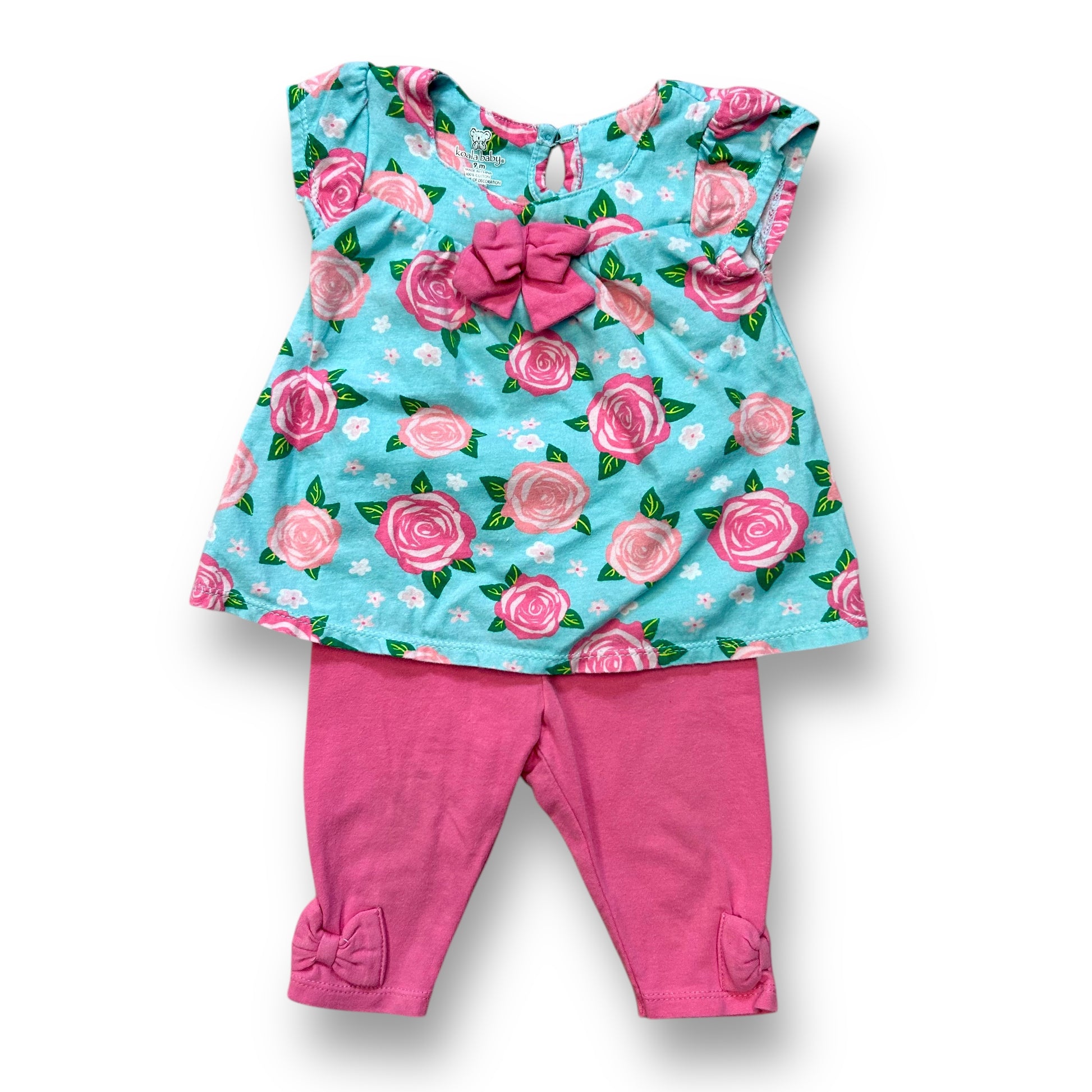 A baby girl's outfit featuring a short sleeve floral print top in pink and aqua colors, and pink pants.