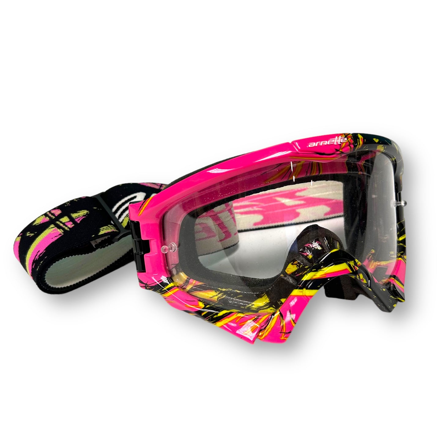 A pair of Arnette motocross goggles with a pink, black, and yellow camouflage design.