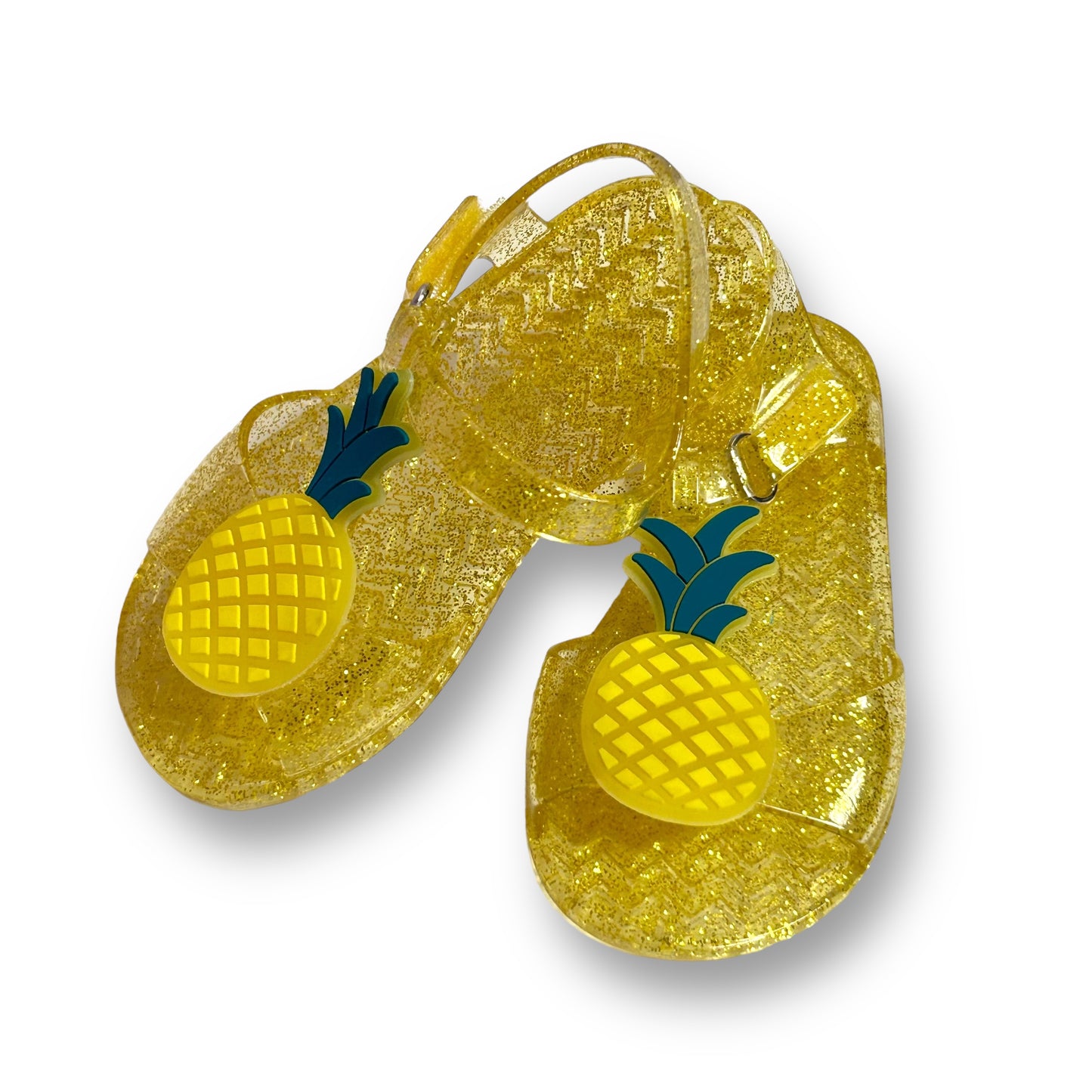 A pair of yellow toddler girl sandals with a pineapple pattern and no buckle.