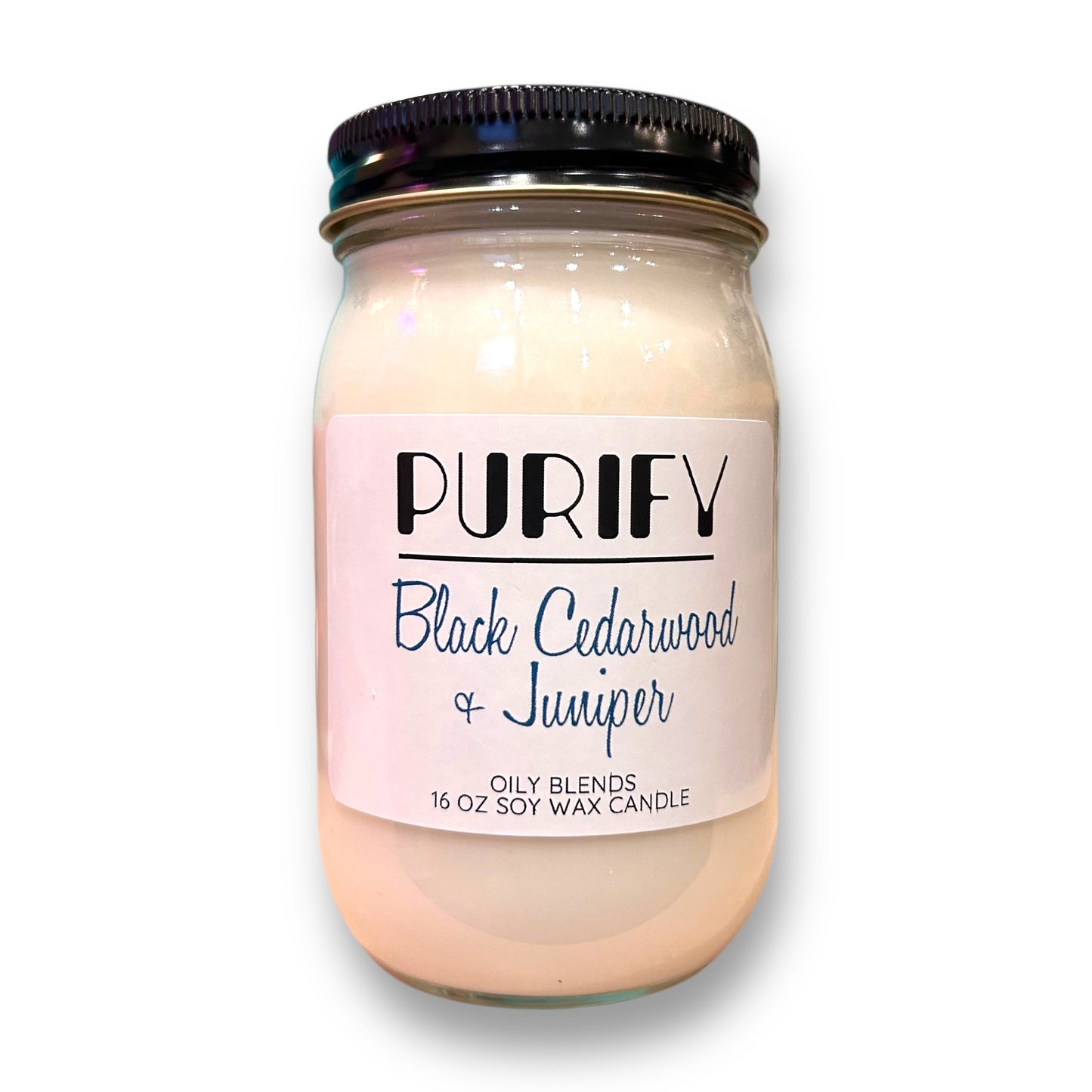 A jar of PurifyV Black Cedarwood + Juniper Soy Wax Candle with a label indicating it is a 16 oz. blend, soy wax blend, and has a pink salt core.