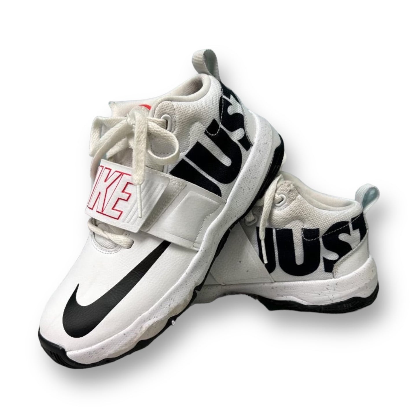 A pair of white Nike athletic sneakers for youth girls, displaying the Nike Logo and 'Just Do It' on the side.