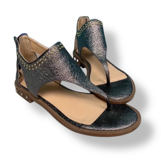 Pair of black and gold sandals on a white background