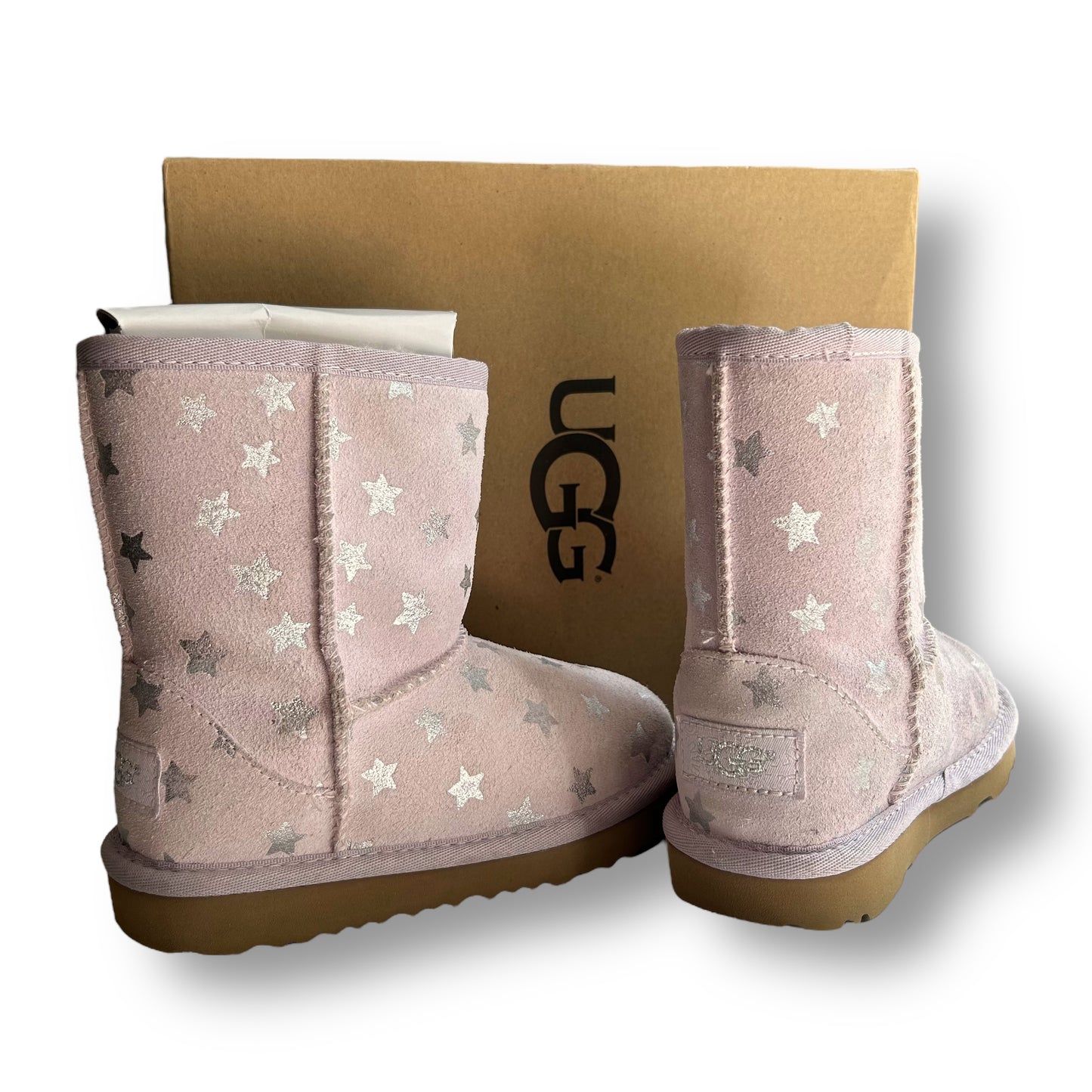 Pink UGG boots with star pattern on a white background