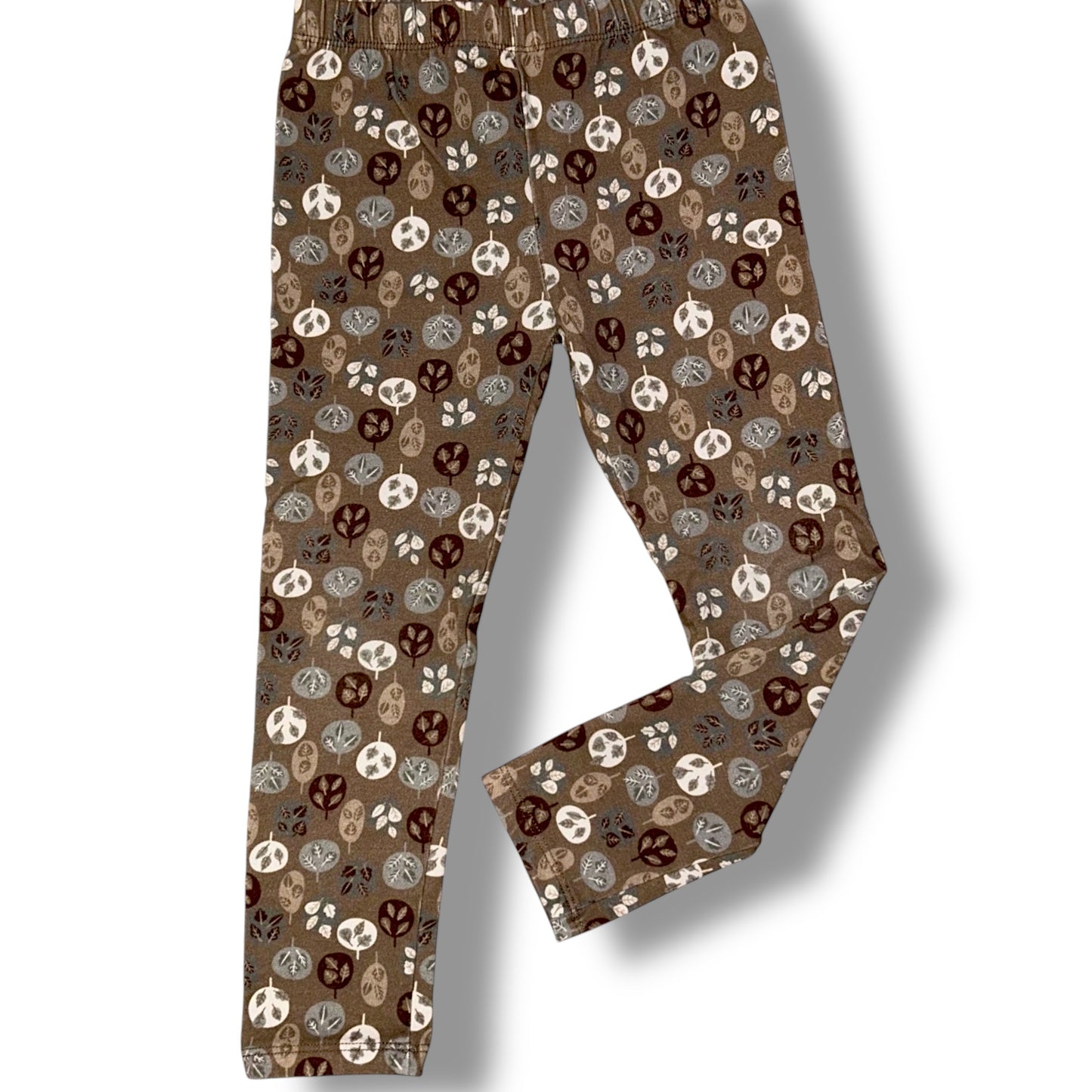Brown pants with a pattern of peace signs and skulls on a white background