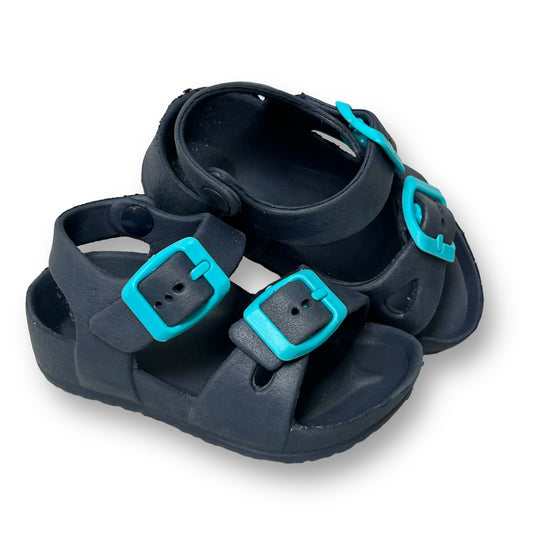 A pair of navy blue toddler boy size 5/6 sandals with a blue buckle and strap.
