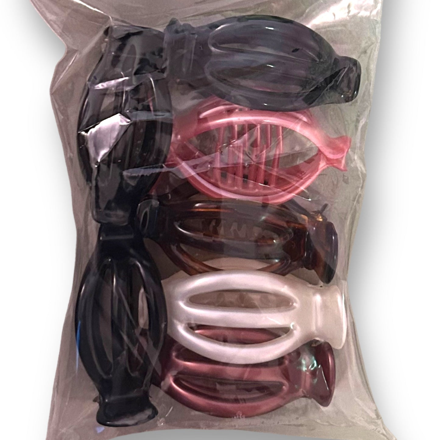 A multi-colored pack of French claw hair clips, visible through a clear plastic packaging.