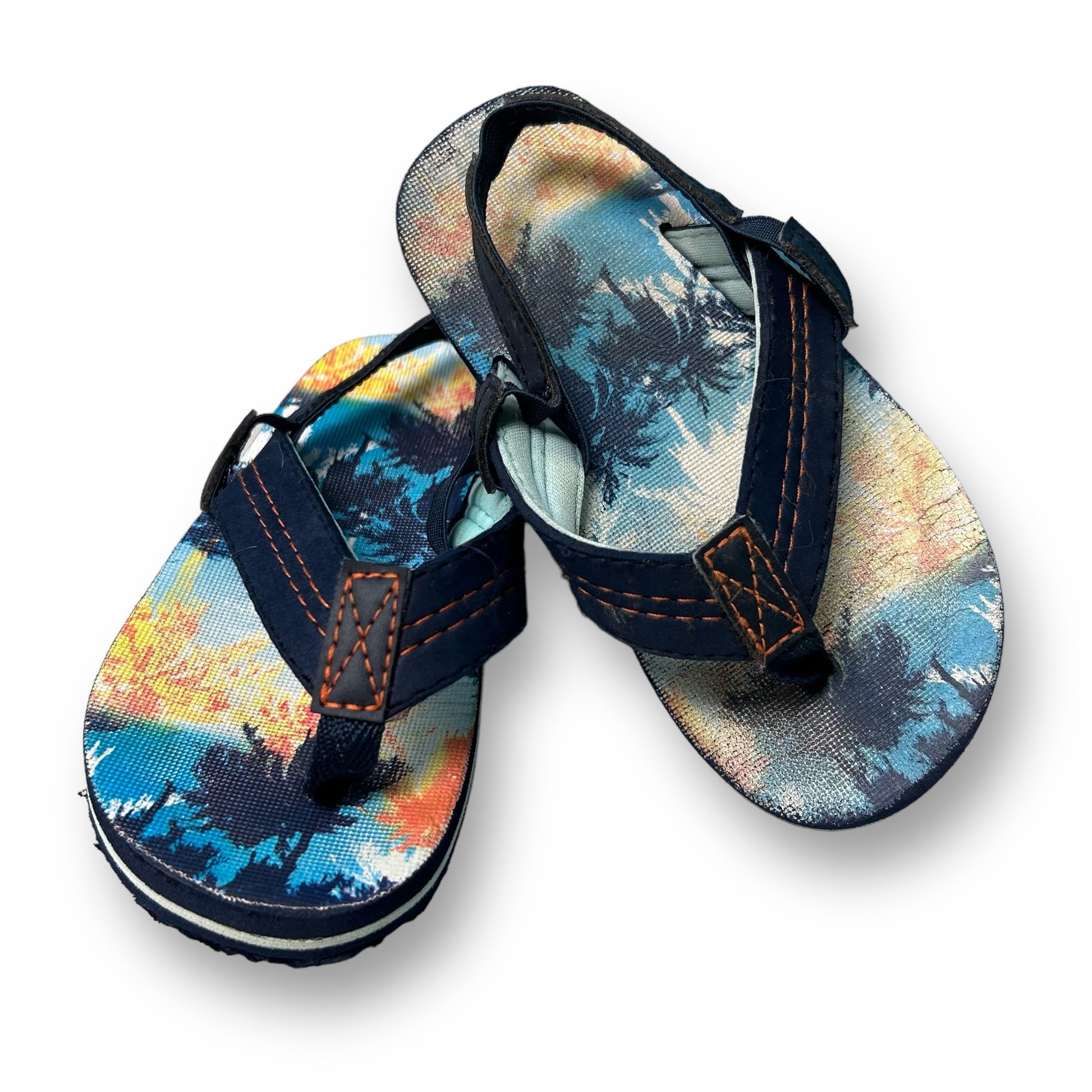 A pair of navy-colored toddler boy size 9/10 comfort fit thong sandals with a floral pattern on the upper part.