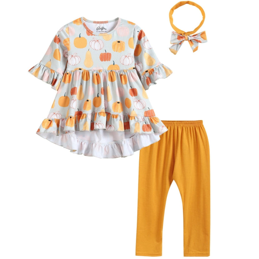 A 5-year-old girl's outfit set, including a hi-lo top with orange and gray pumpkin print, capris, and a headband with a bow.
