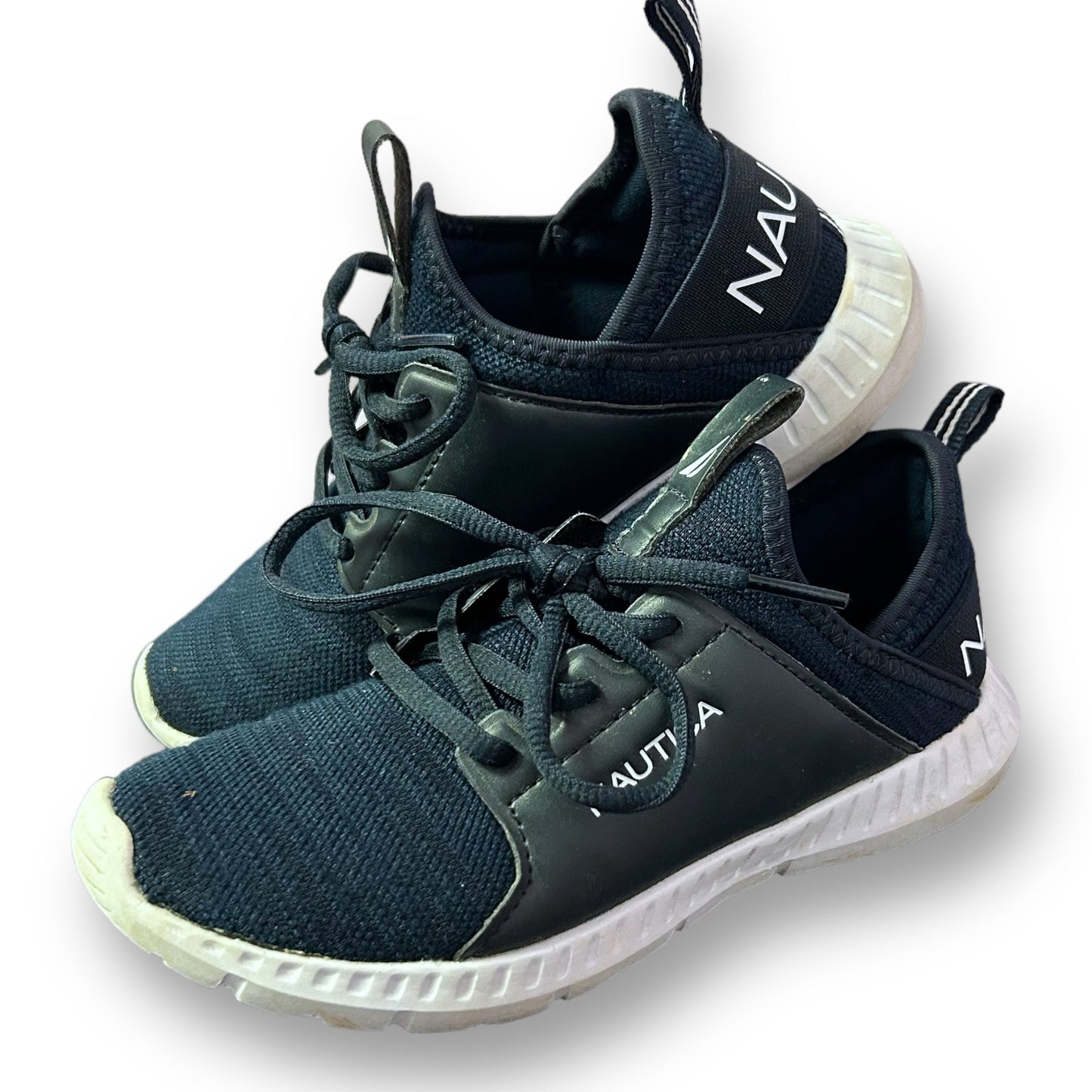 A pair of navy blue Nautica youth tennis shoes with a no-tie design and white sole.