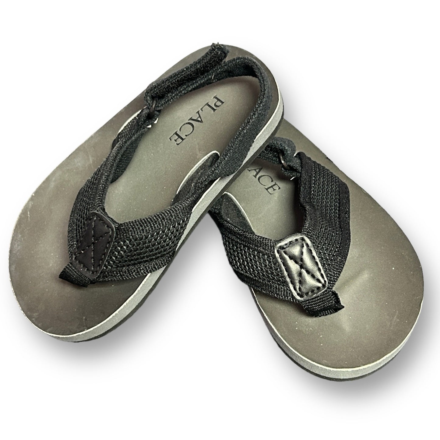 A pair of Children's Place toddler boy summer sandals in black and gray with Velcro straps.