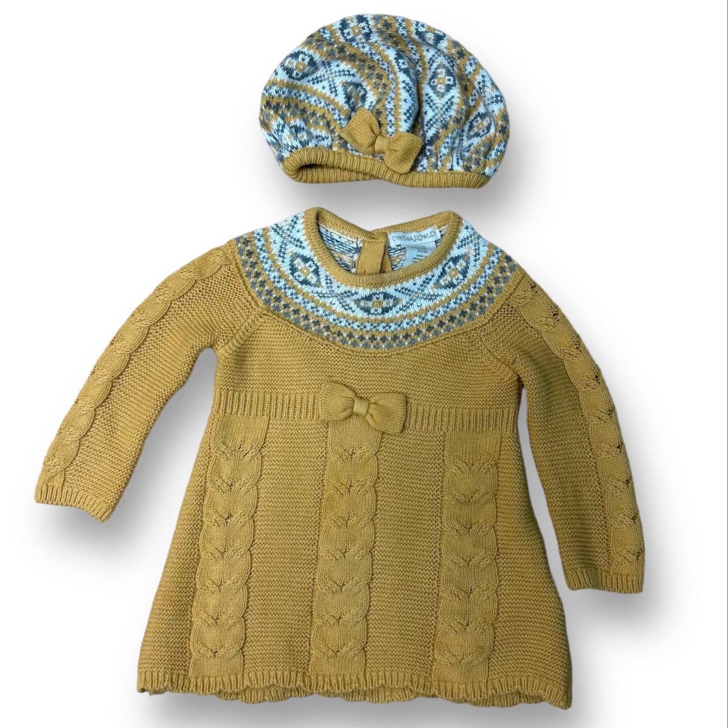 A mustard-colored, 2-piece Cynthia Rowley sweater dress for girls, sized 3-6 months, complete with a matching hat adorned with a blue and brown paisley pattern.