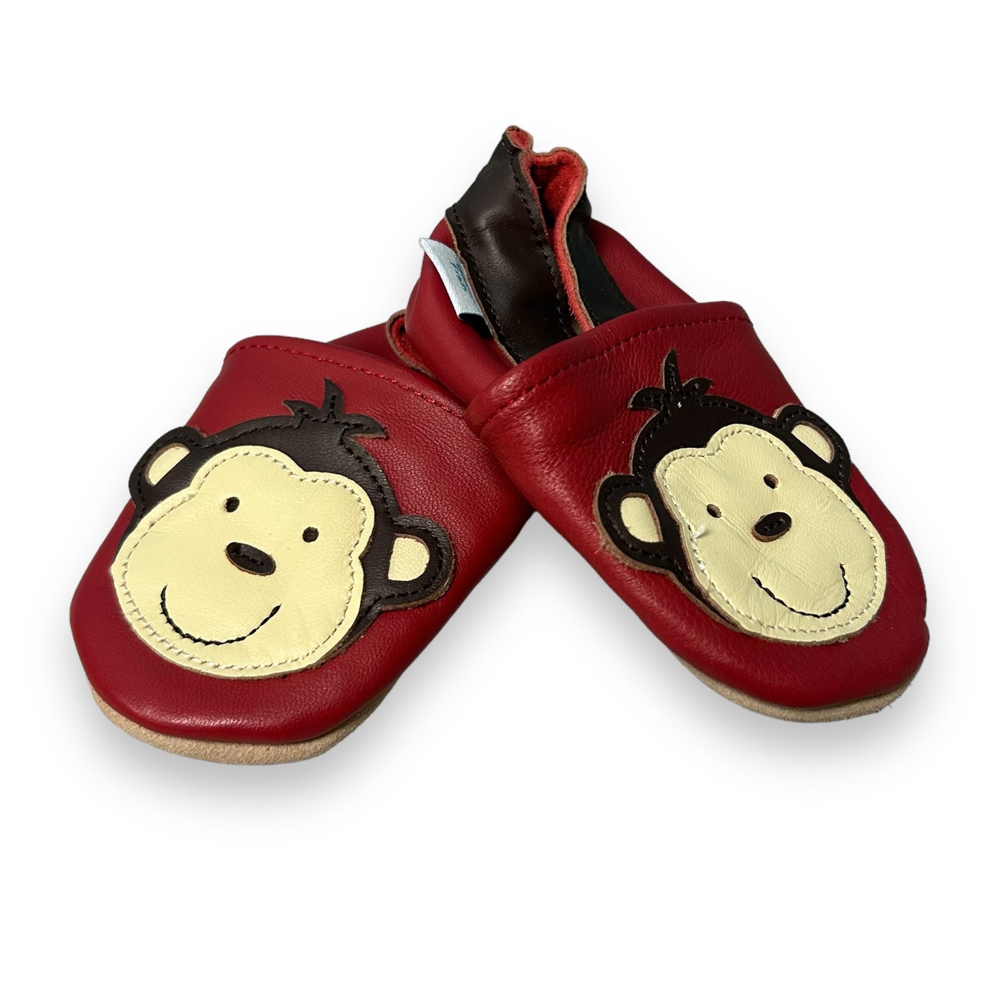Red leather baby shoes with a monkey pattern and orange heel accents.