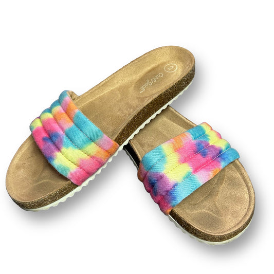 A pair of youth girl size 2 tie-dye slide-on sandals with orange, pink, blue, and yellow colors.