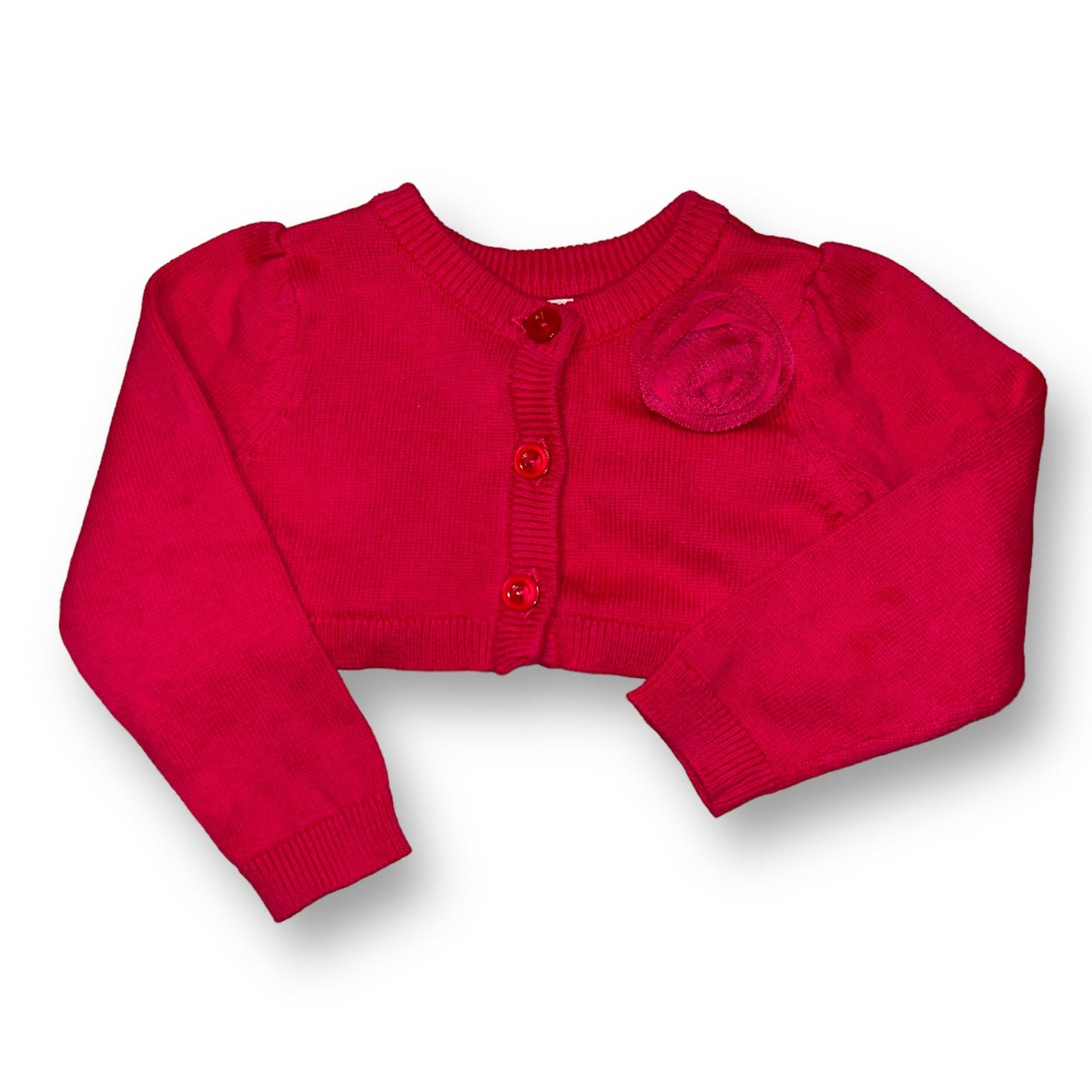 A pink long sleeve cropped sweater for girls, with a round neckline and a small ruffled detail on the chest area.