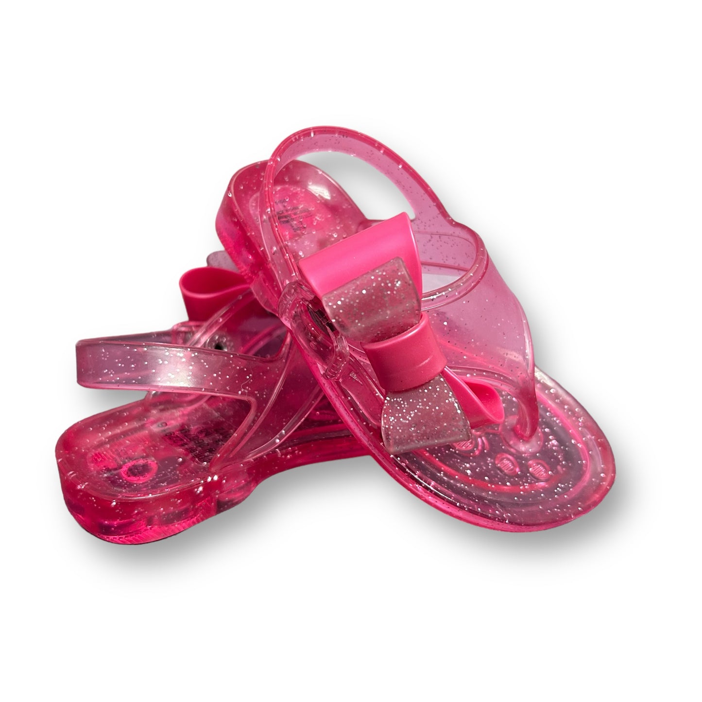 A pair of pink jelly thong sandals with glitter accents.