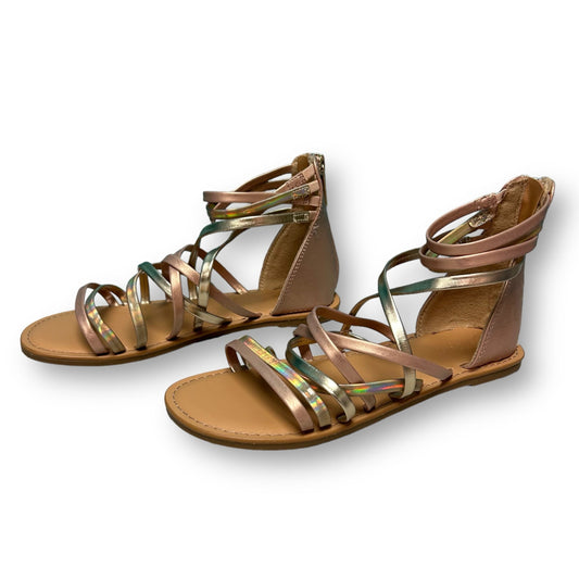 A pair of youth-sized rose gold zipper back sandals with two straps and a flat, platform sole.
