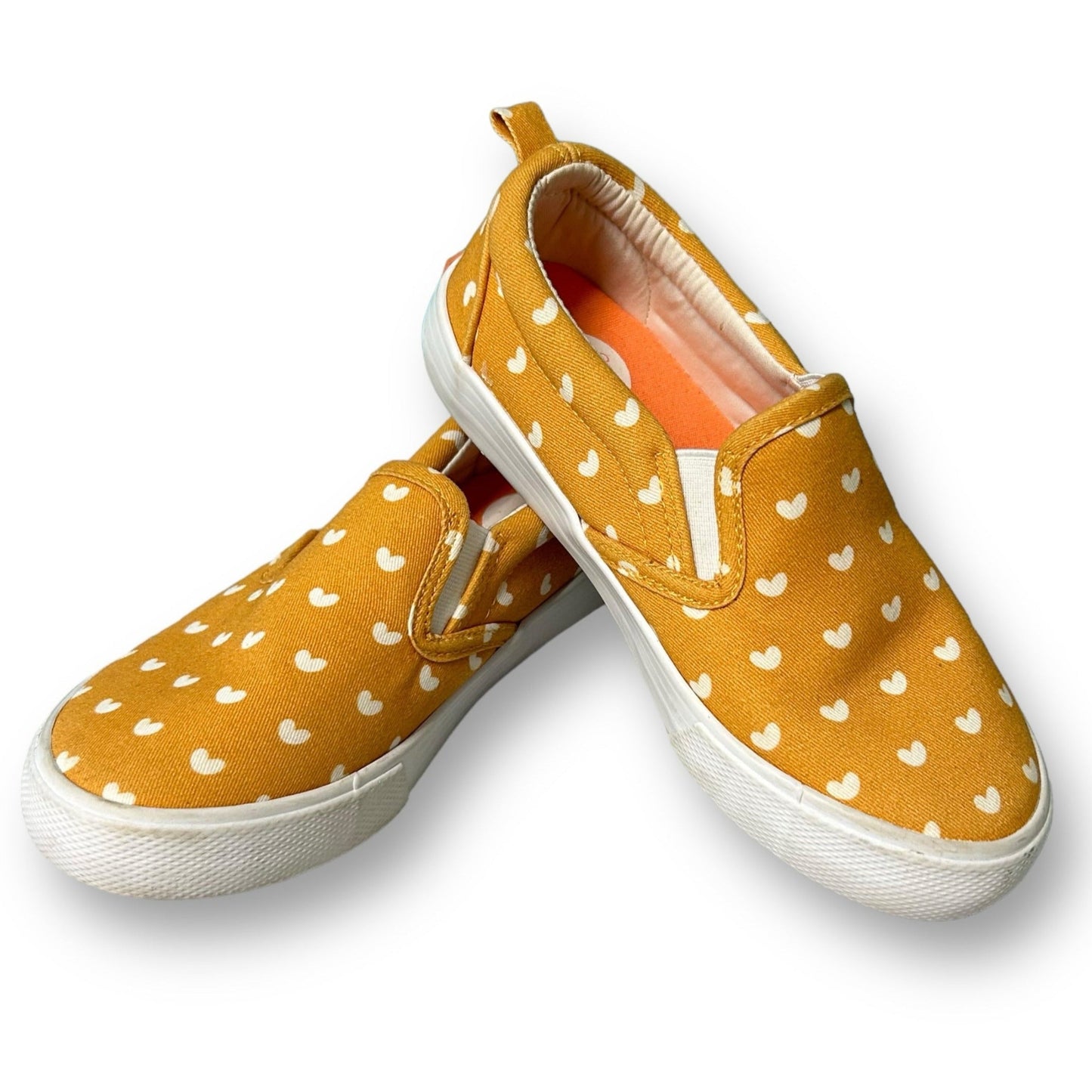 A pair of mustard yellow slide-on sneakers with heart patterns, designed for girls' size 12.