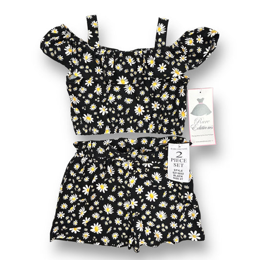 A black and white daisy-patterned 2-piece outfit for girls, displayed on a hanger with the brand tag visible.