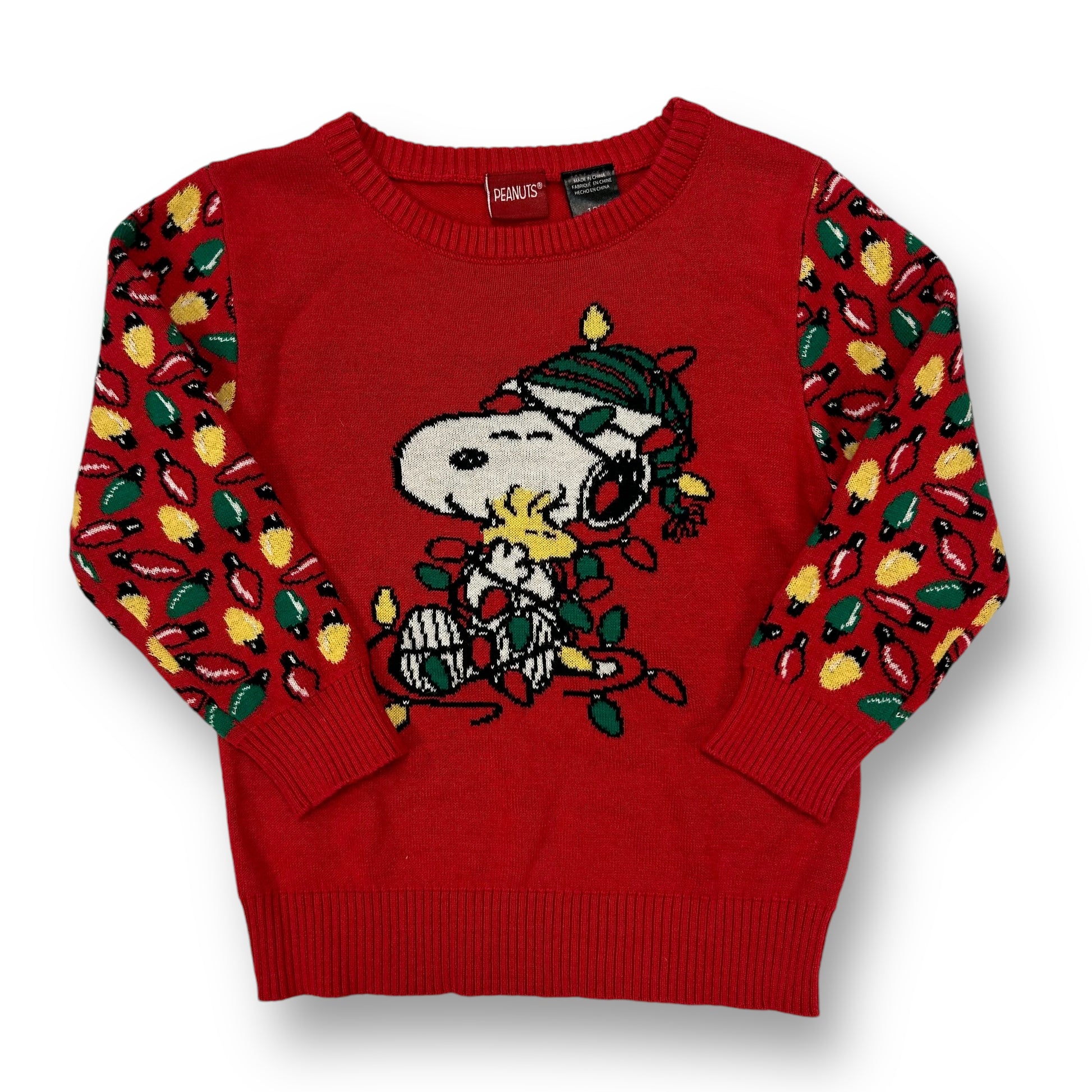A red Christmas-themed sweater featuring a 'Peanuts' character design, with green and red decorations on a knitted texture.