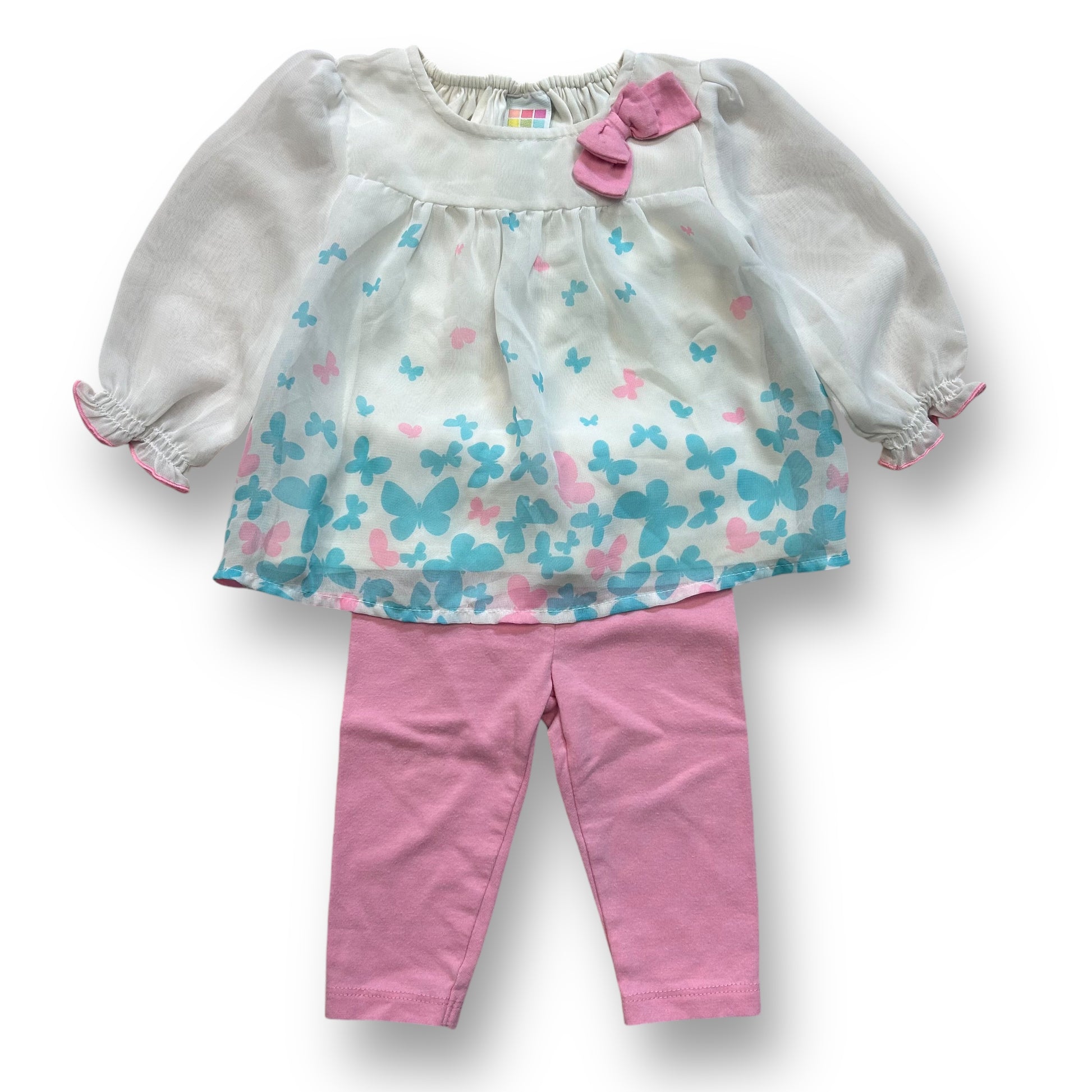 A girls' outfit with a white and pink butterfly blouse and pink leggings.