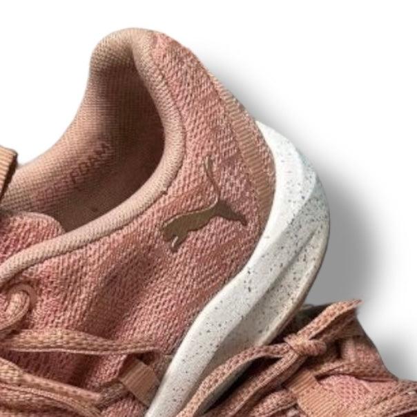 Close-up of a pink sneaker with a white sole on a light gray background
