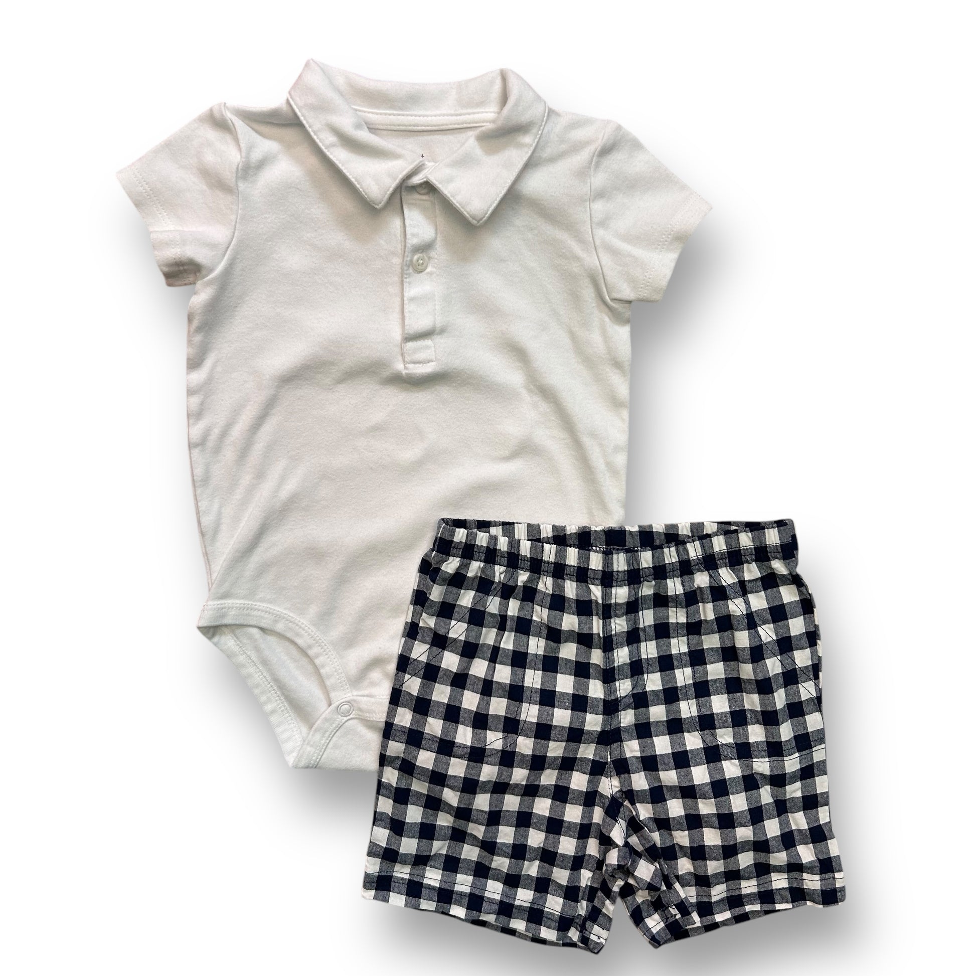 A toddler boys' outfit with a white polo shirt and checkered shorts, laid out on a white background.
