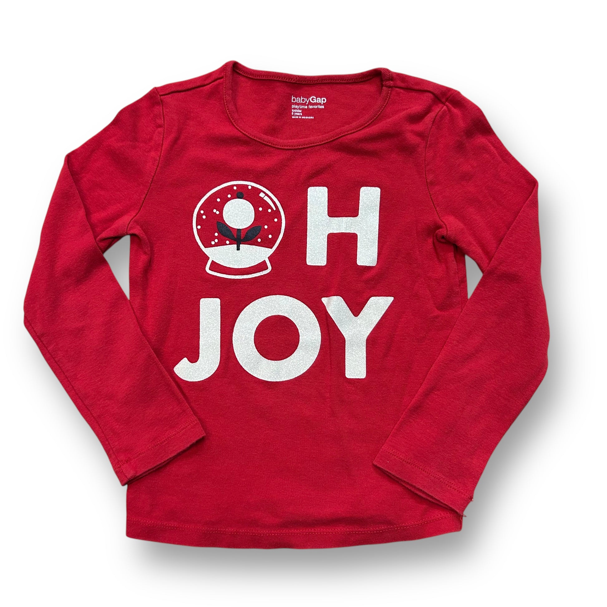 A long sleeve red Christmas shirt with 'Oh Joy' text and a circular design with a Christmas theme.