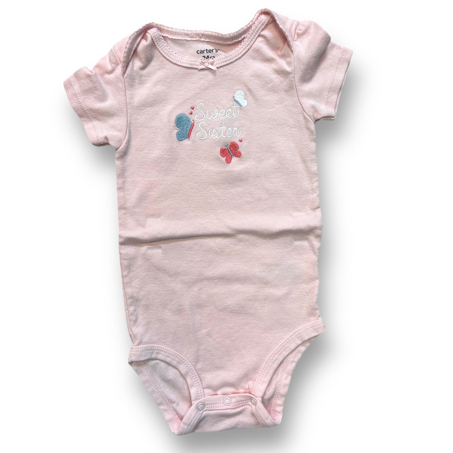 A pink short-sleeve bodysuit for a 24-month-old girl with a graphic print and a snap bottom.