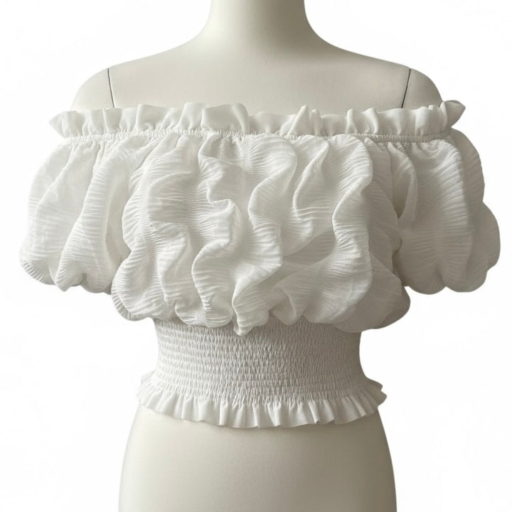 White off-shoulder top with ruffled details on a mannequin against a white background