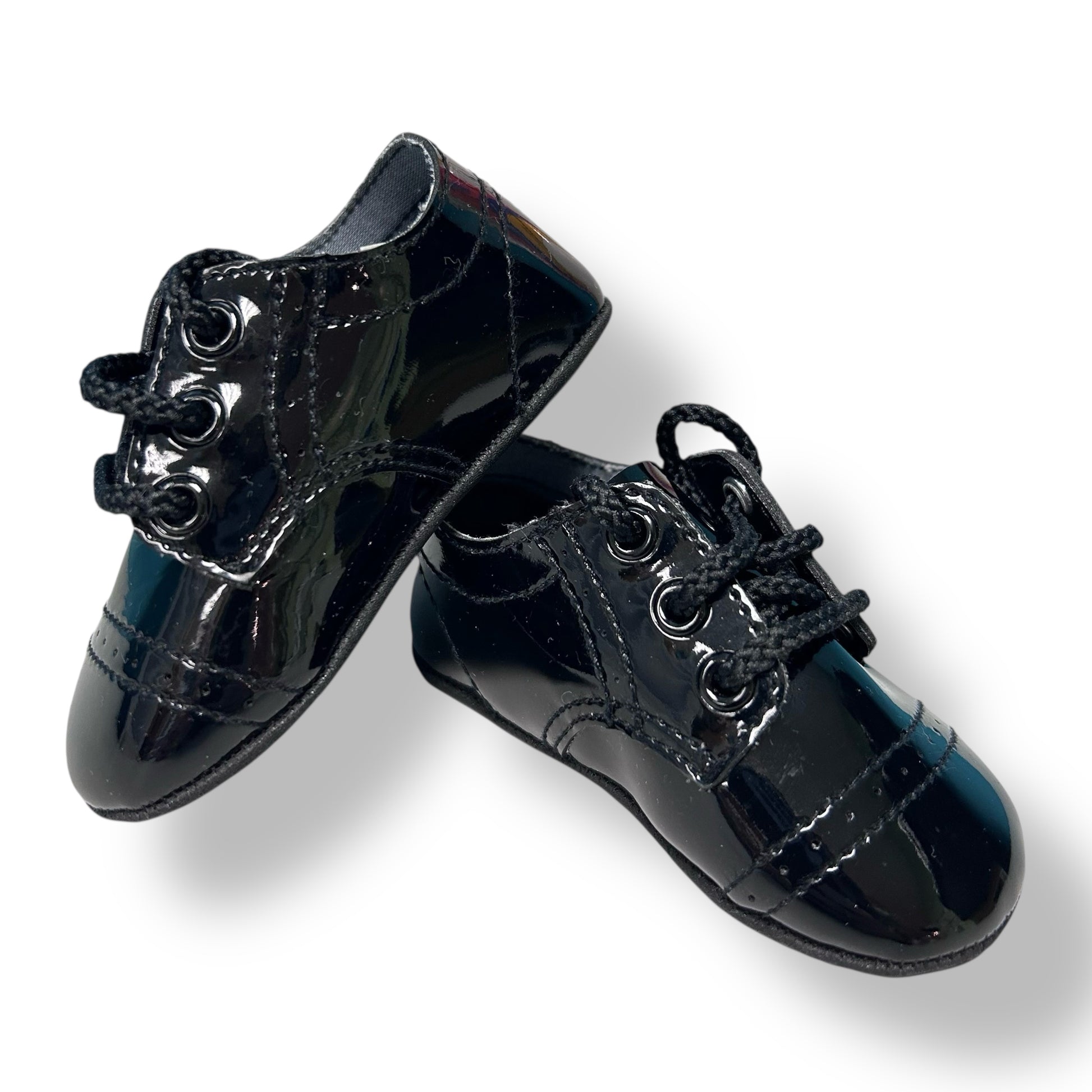 Pair of black patent leather shoes on a white background