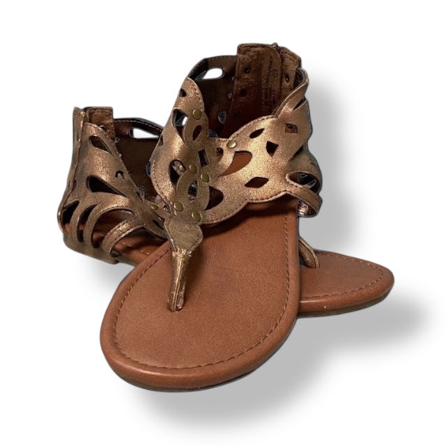 Bronze sandal with cut-out design on a white background