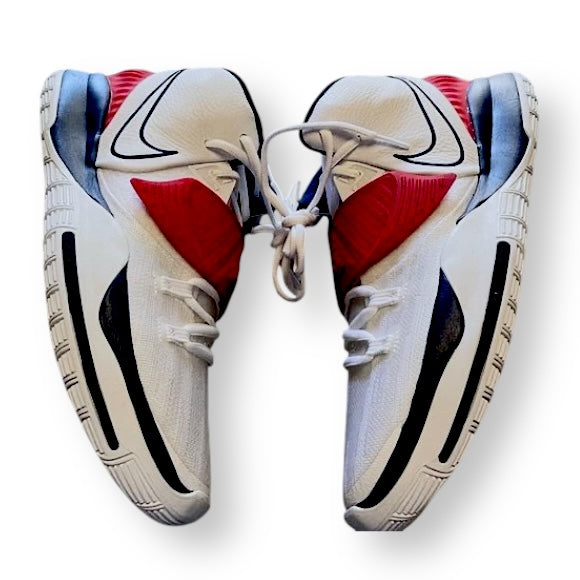 Pair of white Nike Kyrie basketball sneakers with red and blue accents on a white background