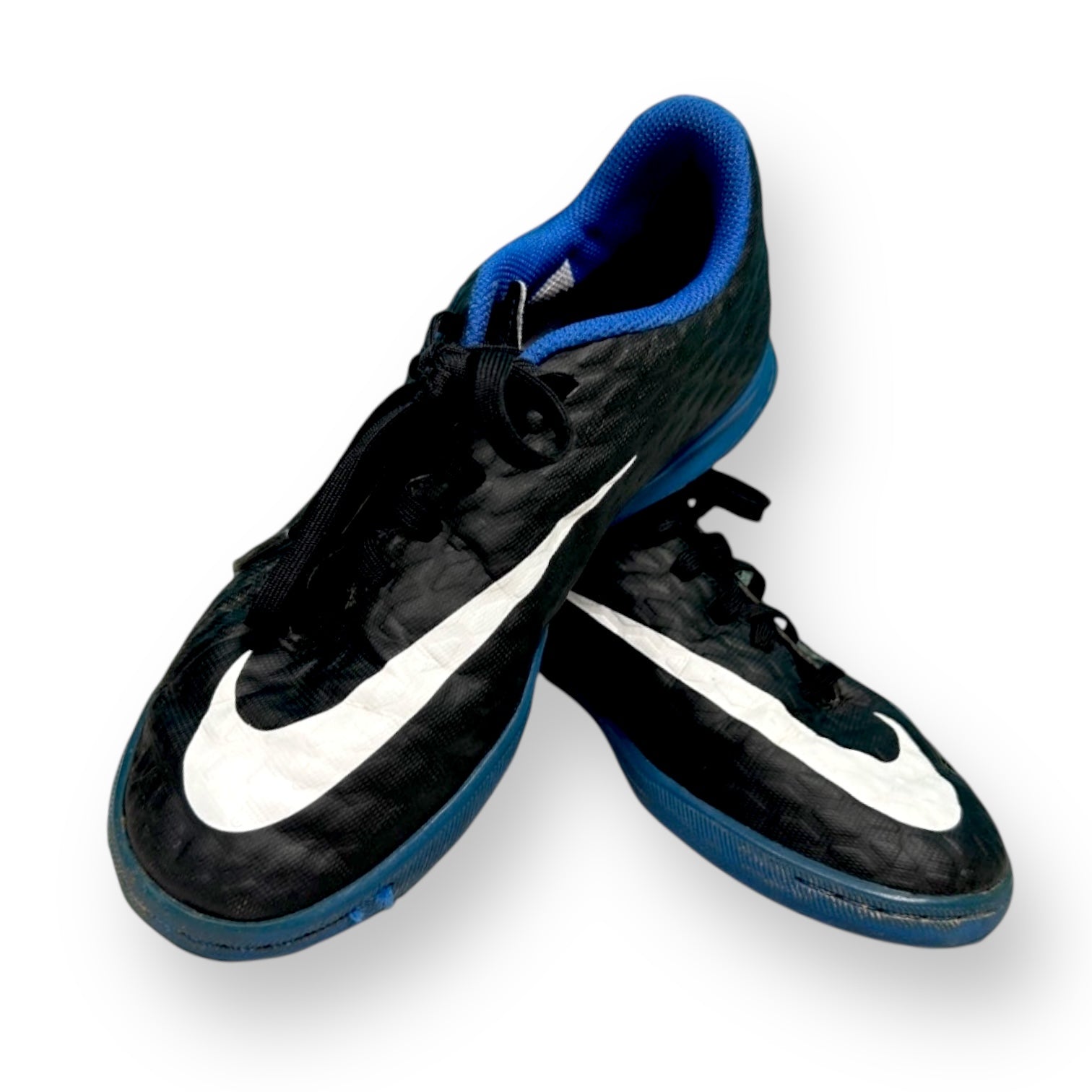 Pair of black and blue soccer cleats on a white background