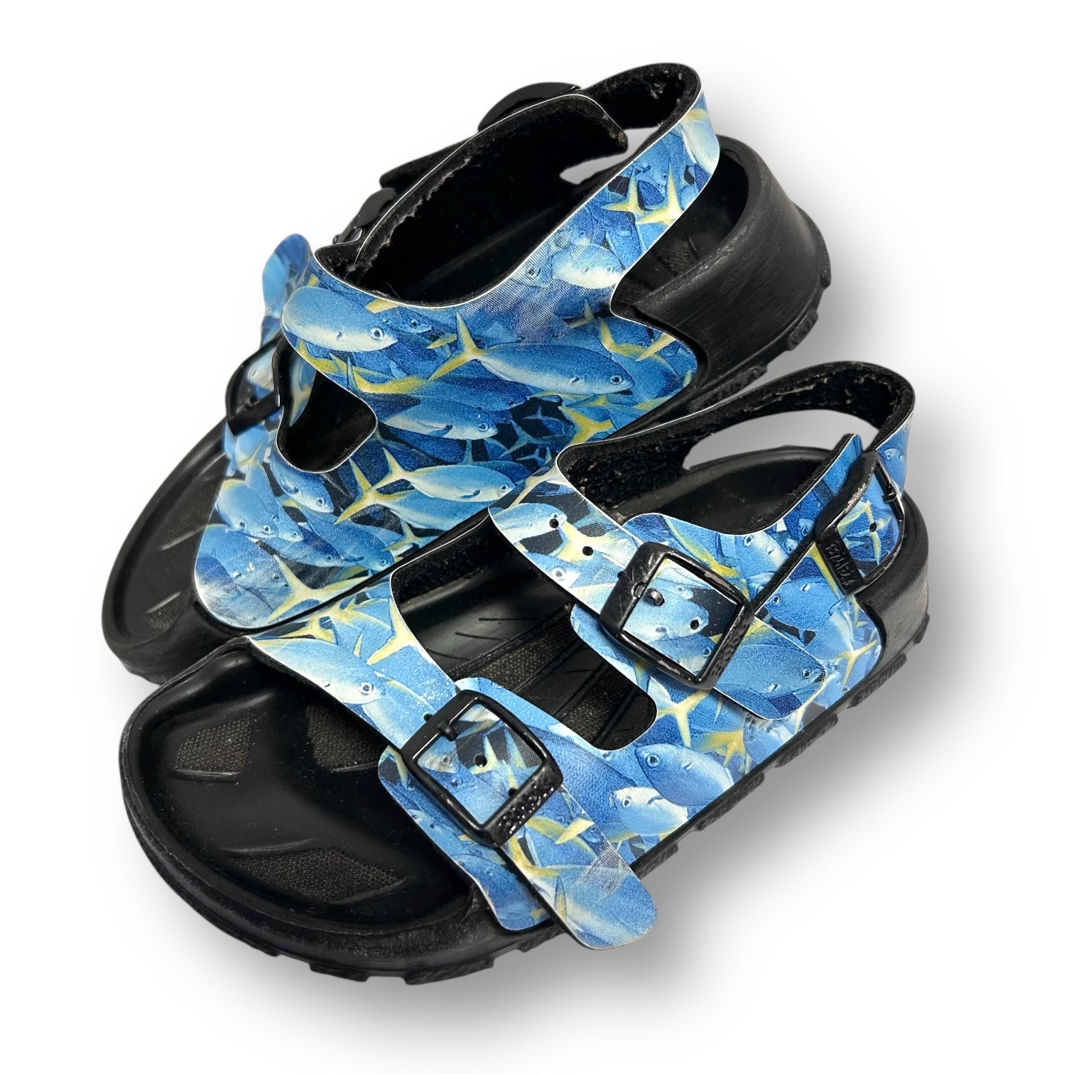 Pair of sandals with blue fish pattern on a white background