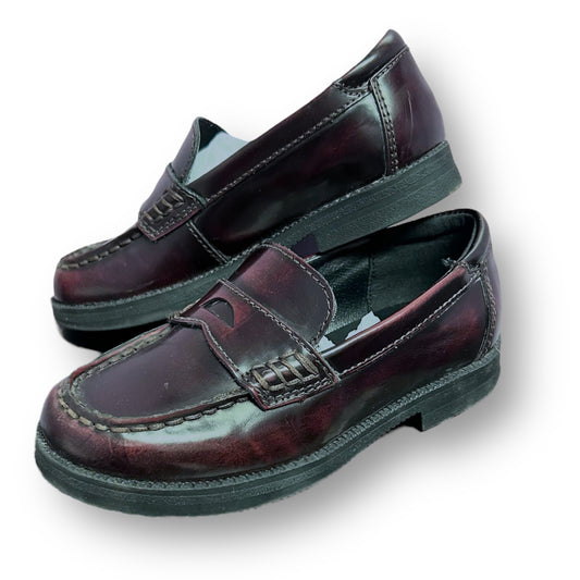 Pair of dark brown loafers on a white background