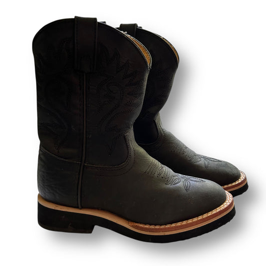 Pair of Justin black leather cowboy western boots with brown soles on a white background