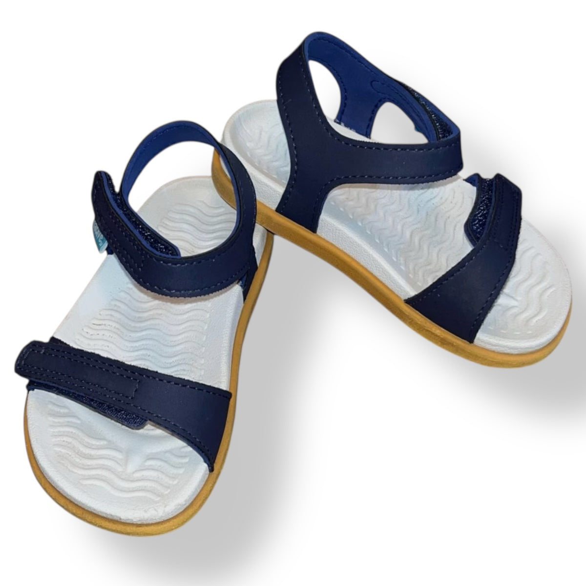 Pair of Native Charley children's sandals with navy straps on a white background