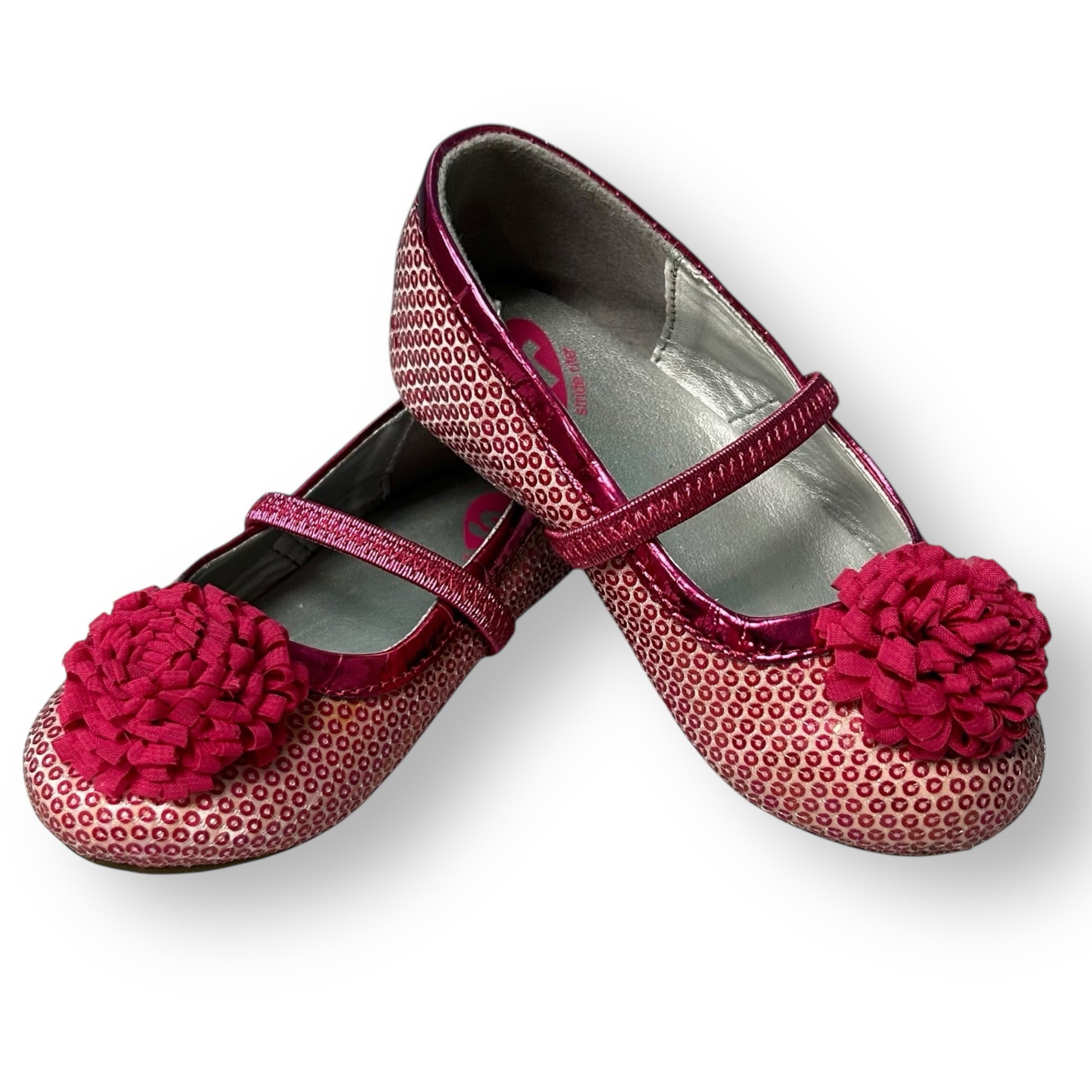 Pair of children's shoes with pink floral decorations on a white background