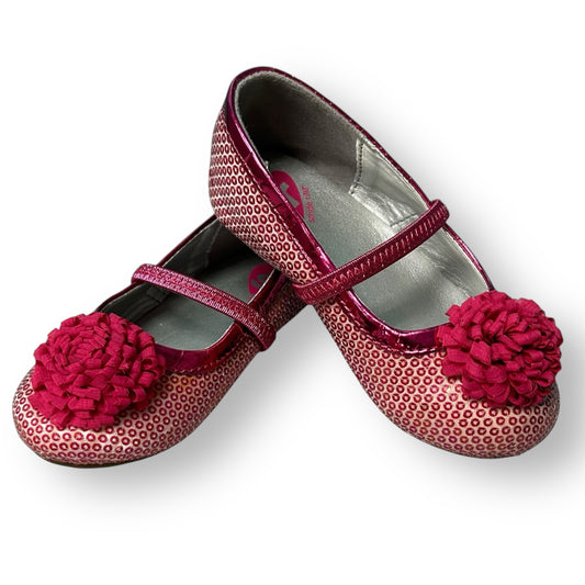 Pair of children's shoes with pink floral decorations on a white background