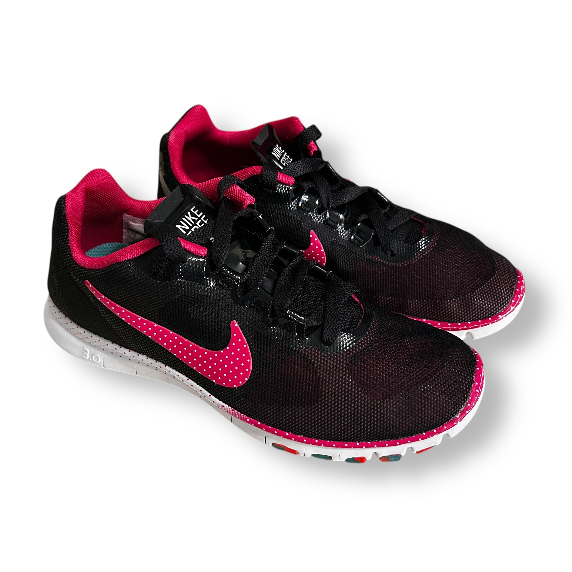 Black and pink Nike running shoes on a white background