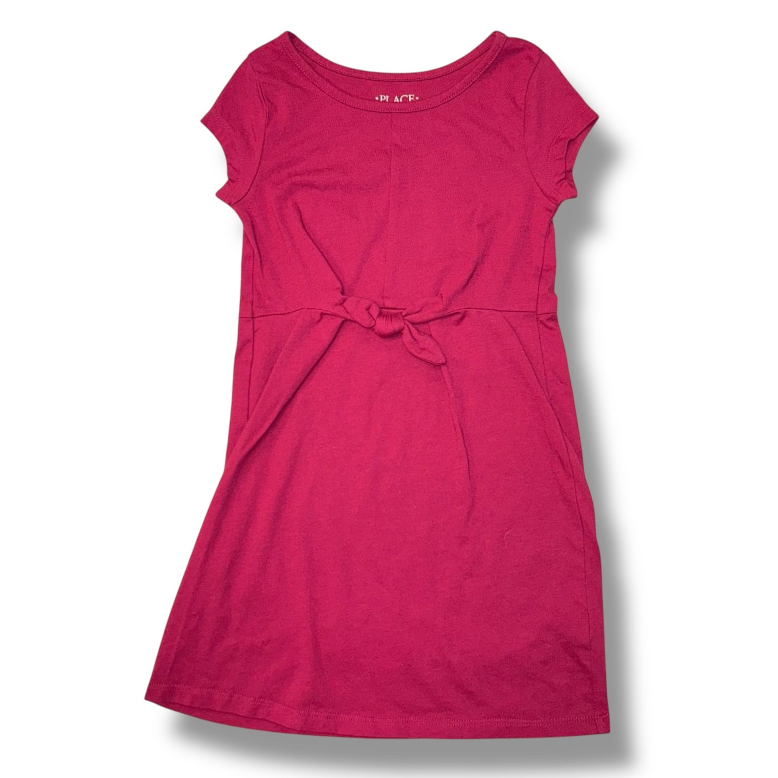 Pink dress with a bow detail on a white background