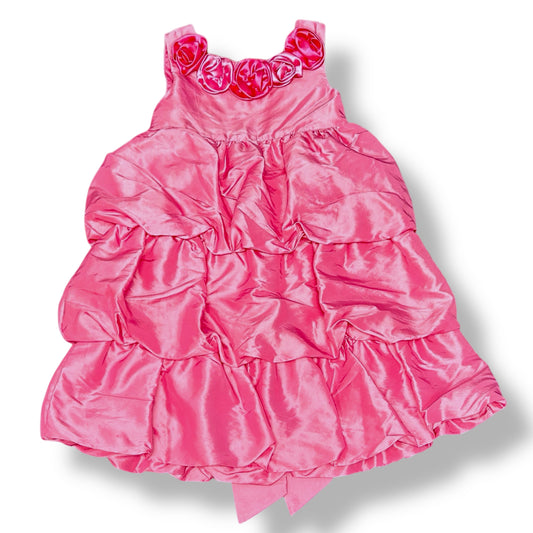 Pink ruffled dress with floral straps on a white background