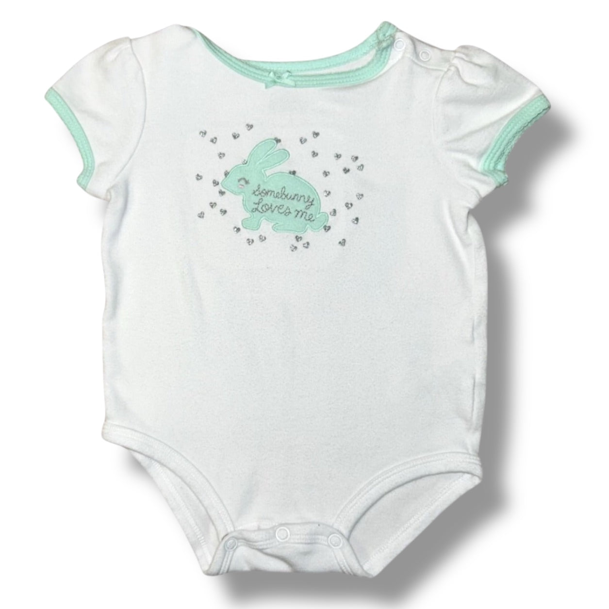 White baby onesie with green bunny design and text on a white background