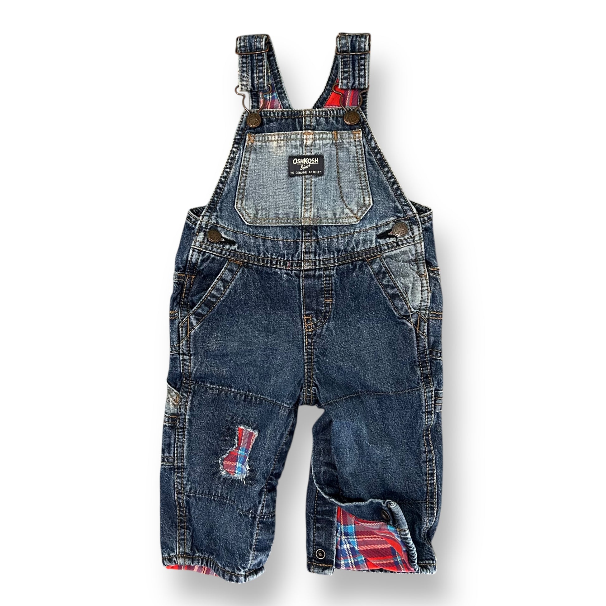 Denim overalls with plaid patches on a white background