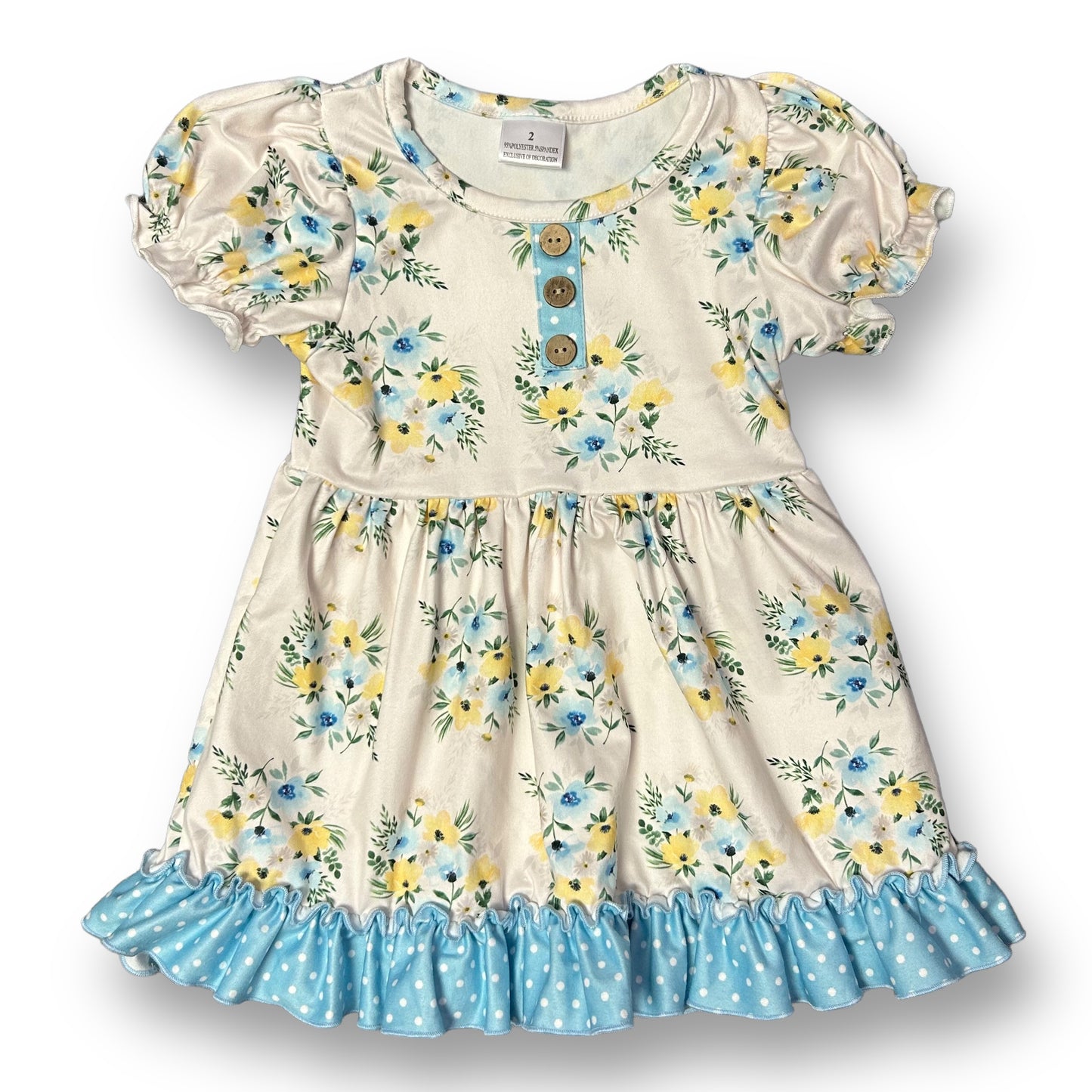 A floral print ivory dress with blue polka dots and a button accent, designed for girls in boutique size 2.
